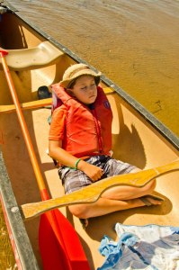 kid sleeping in a canoe