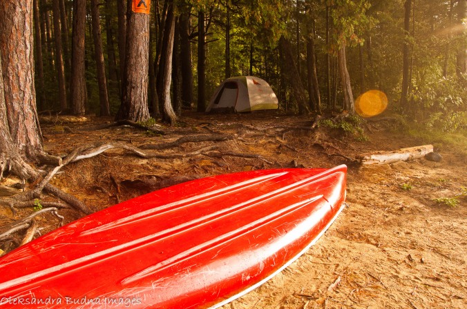 early morning at a campsite - tent and red canoe