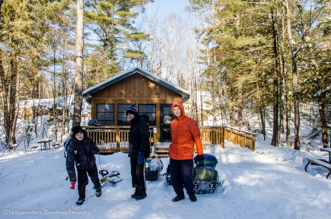 pulling gear in sleds in front of a cabin in Killarney