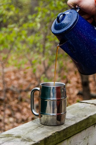 pouring coffee into a mug at a campsite