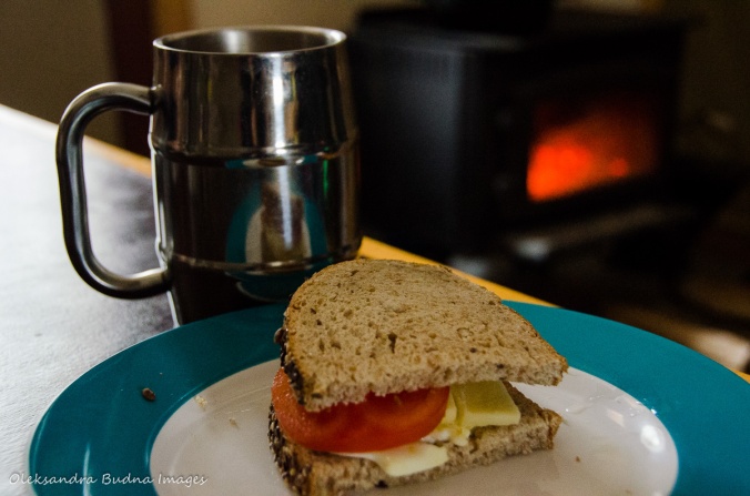 sandwish and a cup of coffee in front of a wood stove in a four-season tent in Gatineau