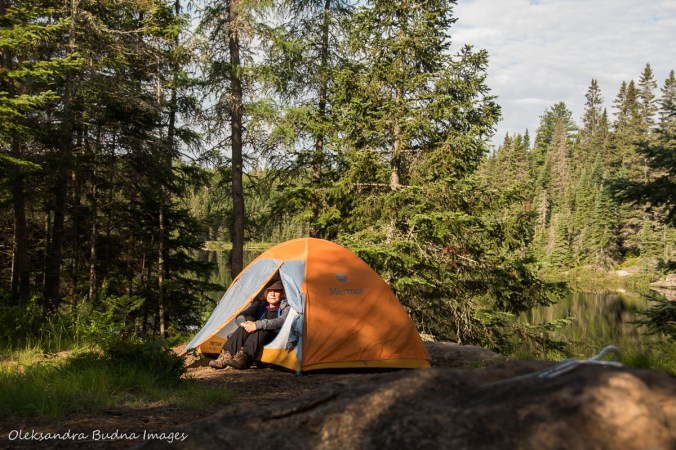 woman sitting by the tent on Faya Lake site in Algonquin
