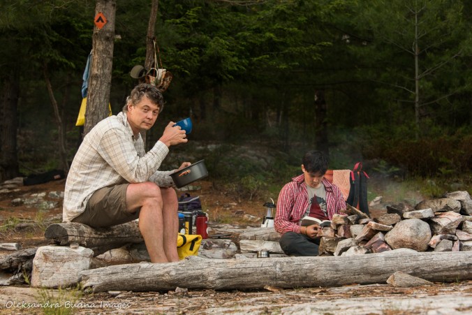 enjoying tea and reading by the firepit on site 179 on Grace Lake in Killarney