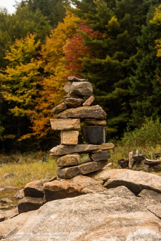 rock sculpture against fall foliage 