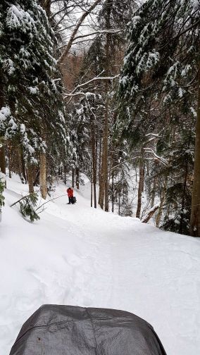 pulling a sled up a hill while transporting gear and supplies at Parc national du Mont-Mégantic in the winter