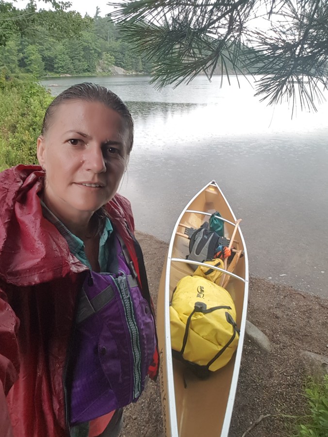 standing by the canoe at a put-in on Johnnie Lake in Killarney